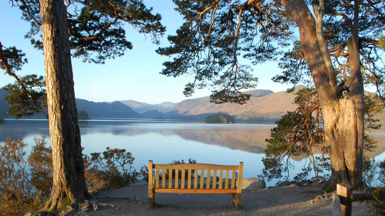 The bench at the viewpoint at Friar's Crag, Derwent Water with hills reflected in the lake